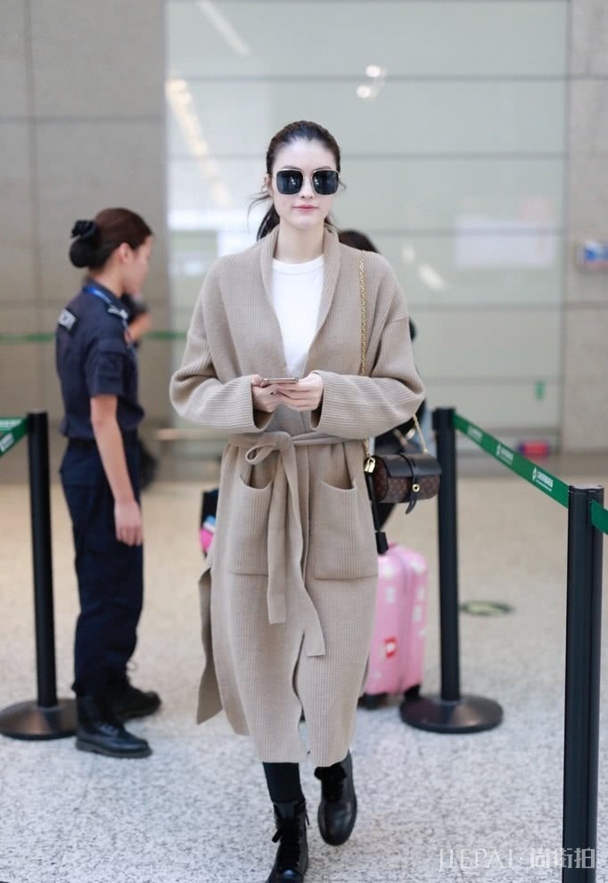 何穗现身机场，针织大衣搭配打底裤，超模也怕冷！