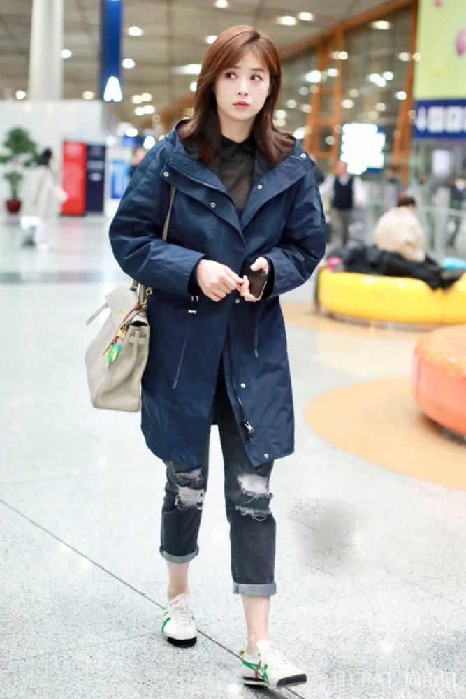 蒋欣现身机场，穿藏青色风衣没有亮点，但仅靠刘海就嫩回到20岁了