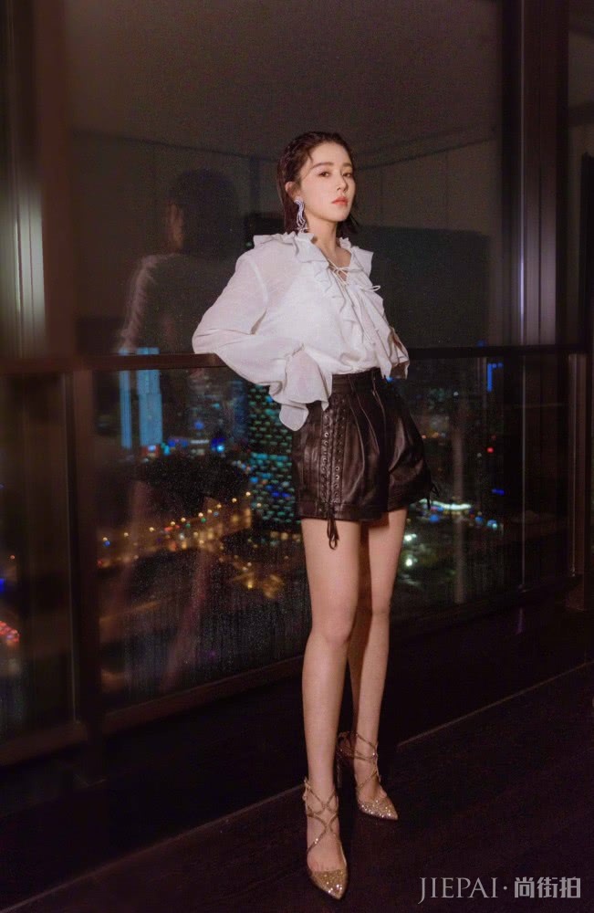 阚清子穿V领上衣配绑带皮裤,衣袖遮脸美艳动人