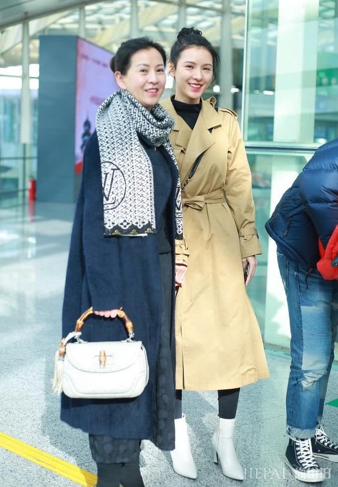 张予曦卡其色风衣搭丸子头牵手母亲走机场