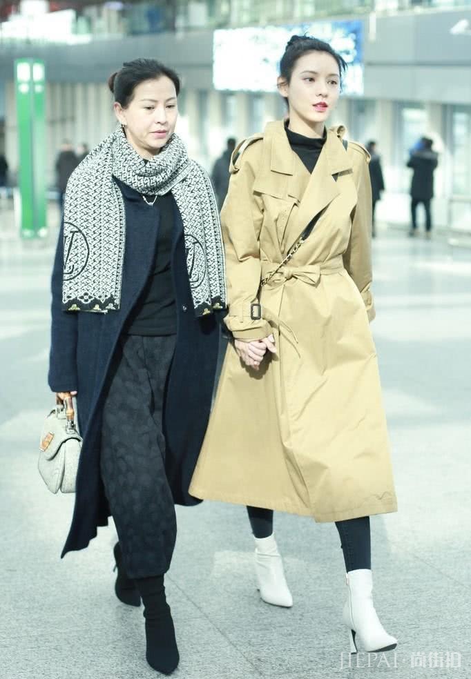 张予曦卡其色风衣搭丸子头牵手母亲走机场