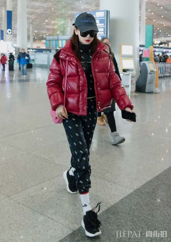 戚薇穿红色亮面羽绒服搭配玫红色皮包现身机场!