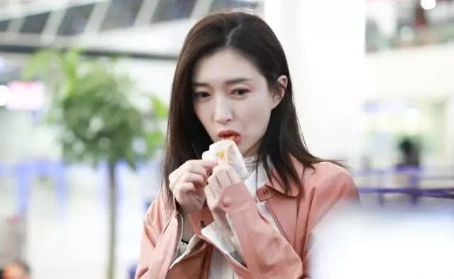 江疏影化身“粉红水蜜桃”，机场狂吃“辣条”，笑成表情包！