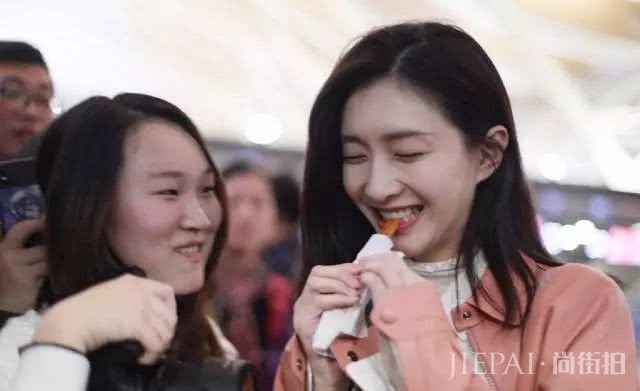 江疏影化身“粉红水蜜桃”，机场狂吃“辣条”，笑成表情包！