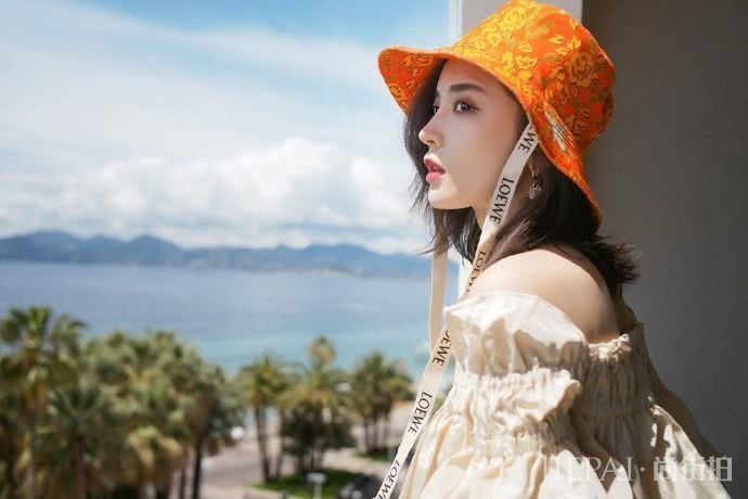 古力娜扎露肩上衣搭配牛仔短裤休闲鞋，搭上渔夫帽更显惬意