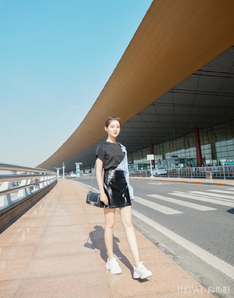 祝绪丹穿拼接衬衫配漆皮裙，双腿修长机场成亮点