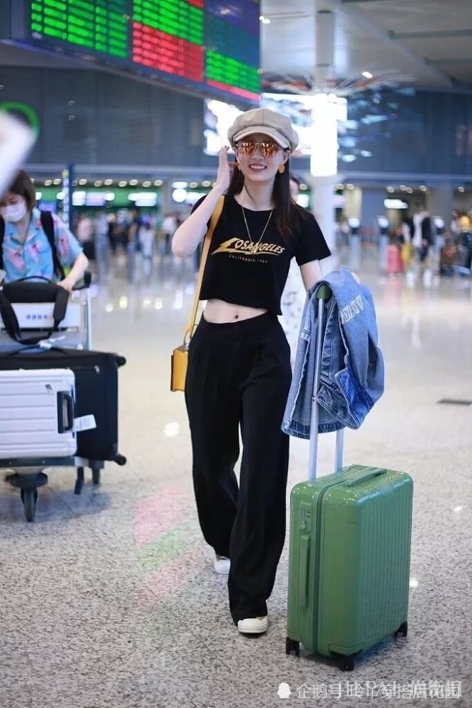 徐璐露脐装配阔腿裤走机场,帽子复古时髦为造型加分
