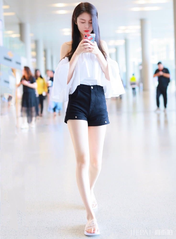 傅菁现身机场，一字肩衬衫配超短裤，双腿细长直比鲜花更抢镜