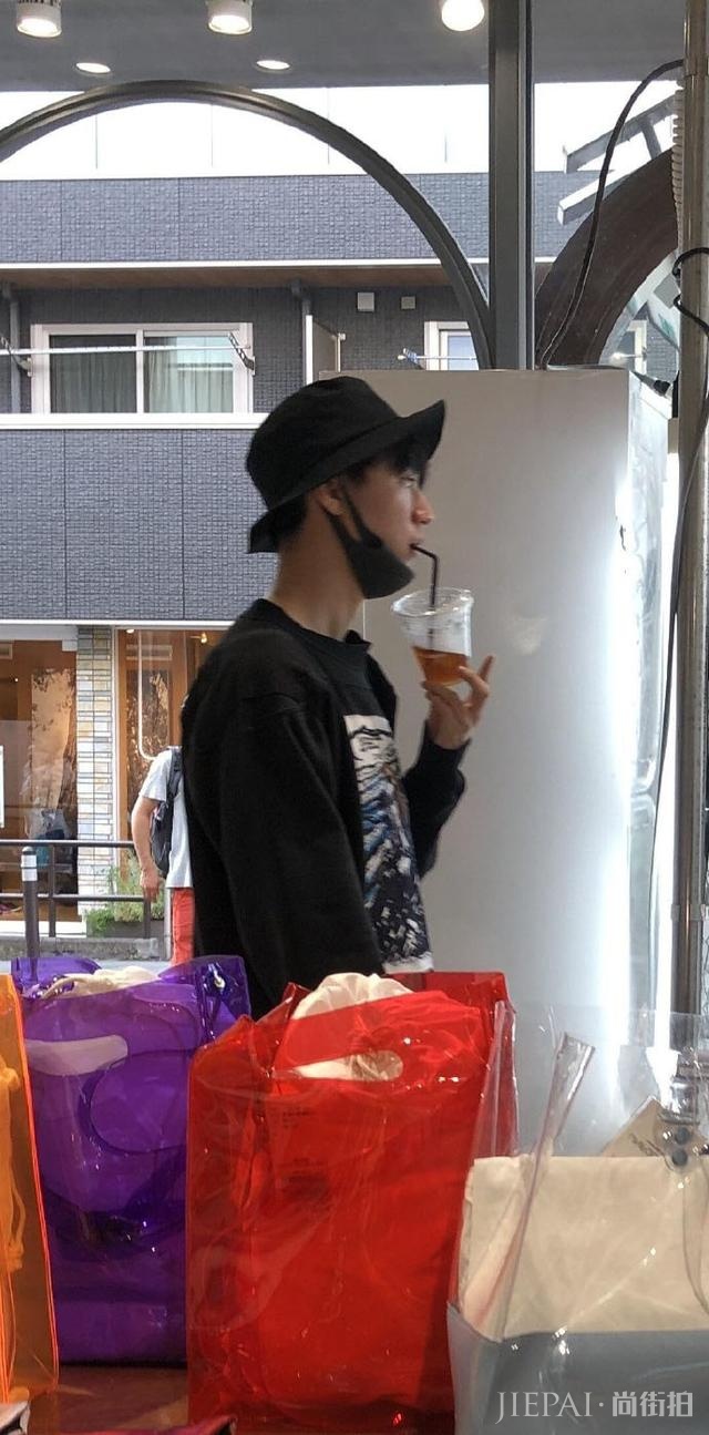 王俊凯在日本被网友偶遇，一身黑色穿着装扮，手里拿着喝的挺可爱