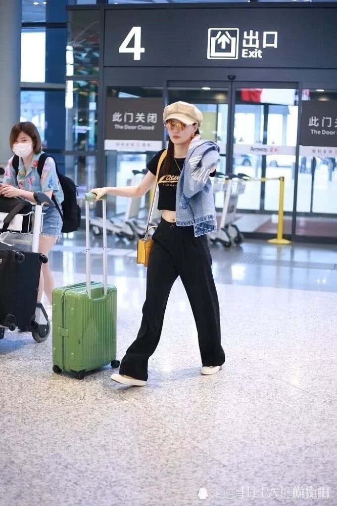 徐璐露脐装配阔腿裤走机场,帽子复古时髦为造型加分