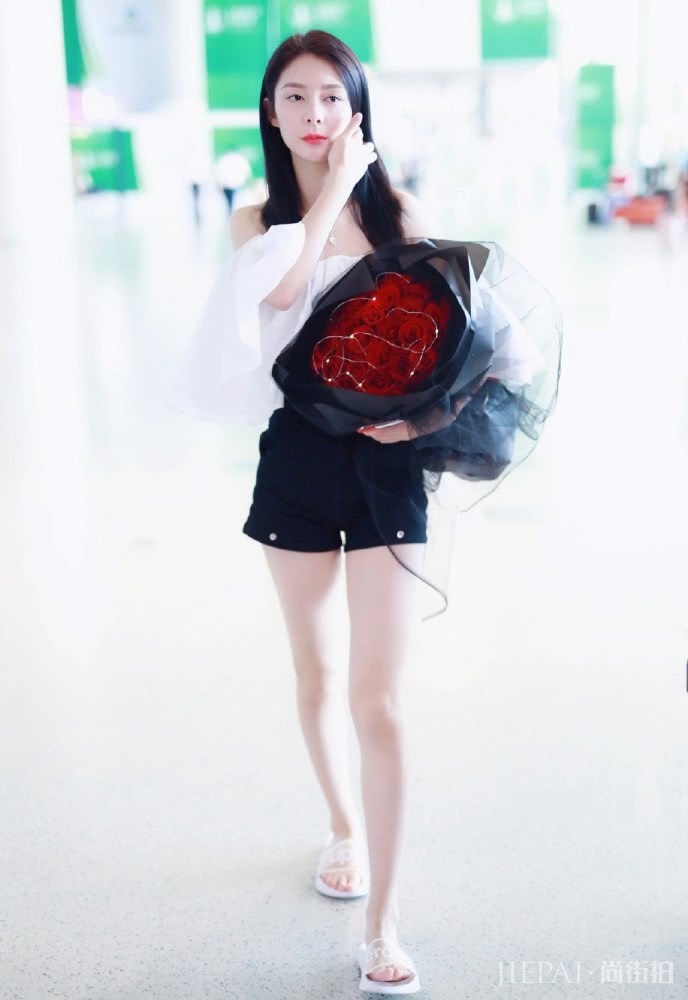 傅菁现身机场，一字肩衬衫配超短裤，双腿细长直比鲜花更抢镜