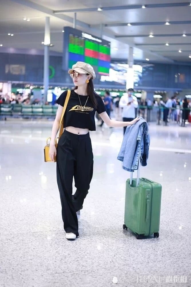 徐璐露脐装配阔腿裤走机场,帽子复古时髦为造型加分