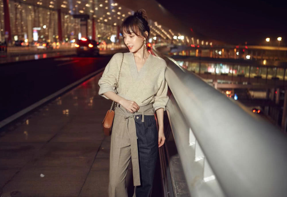 吴昕身穿燕麦色上衣，搭配拼色阔腿裤，时装周之旅秒变大长腿