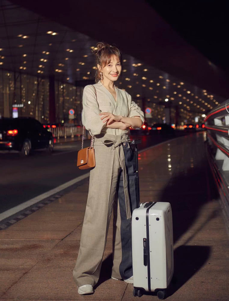 吴昕身穿燕麦色上衣,搭配拼色阔腿裤,时装周之旅秒变大长腿