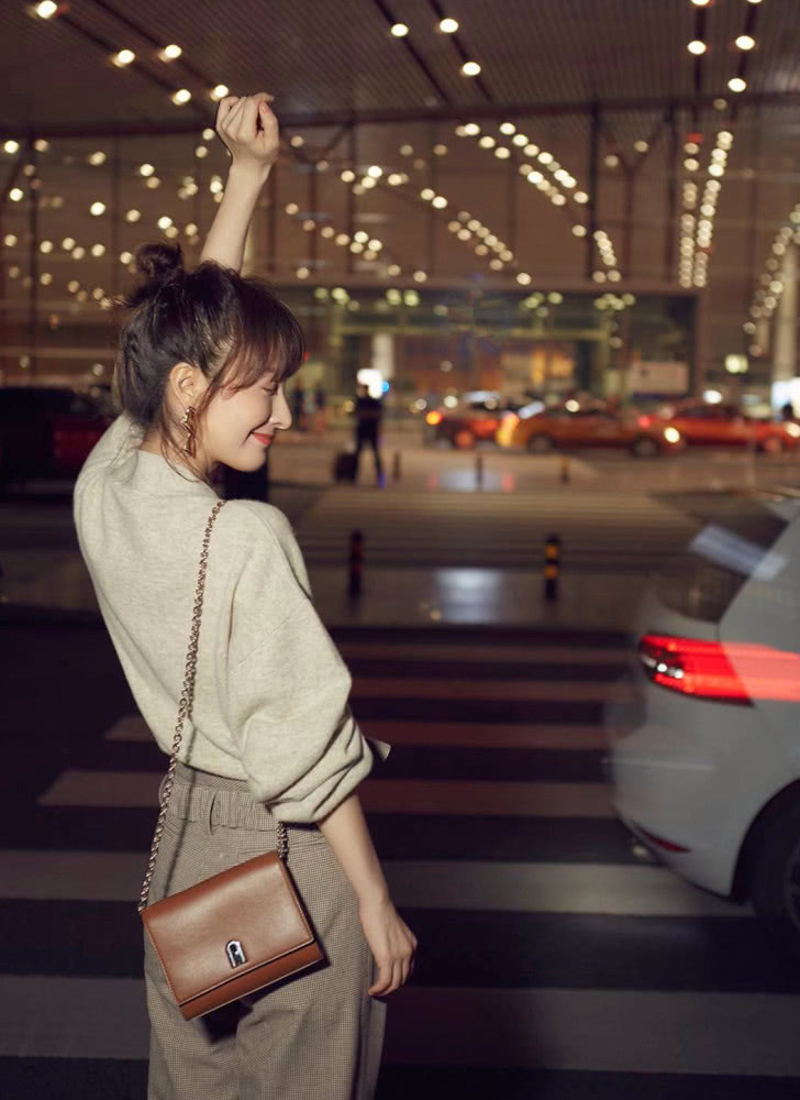 吴昕身穿燕麦色上衣，搭配拼色阔腿裤，时装周之旅秒变大长腿