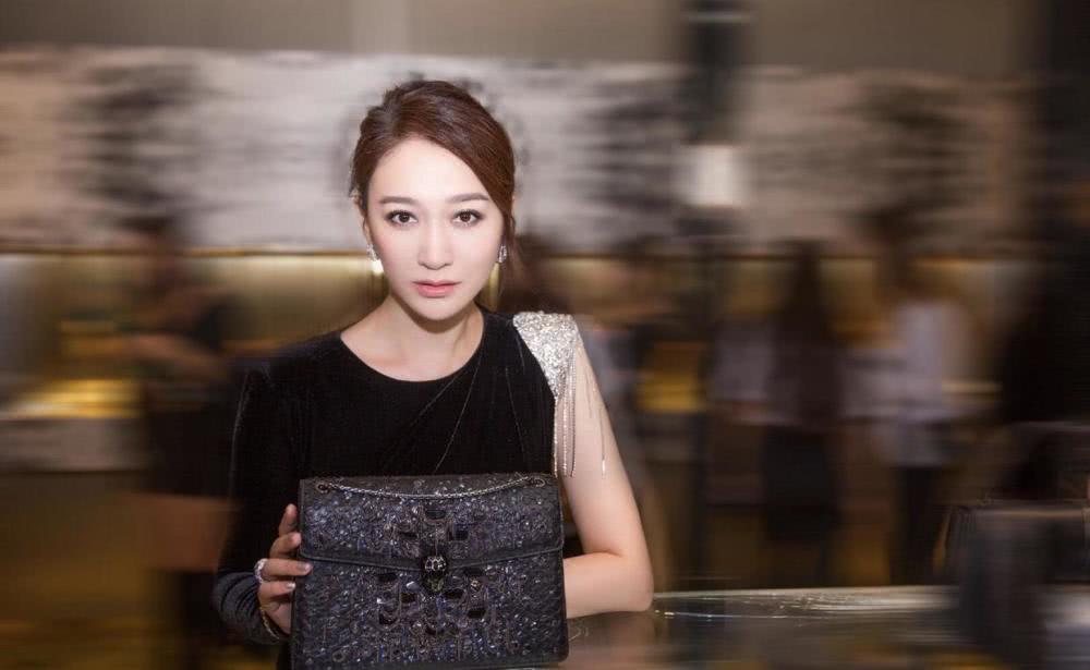 李小冉扎丸子头略显低调，身穿拼接色连衣裙优雅高贵