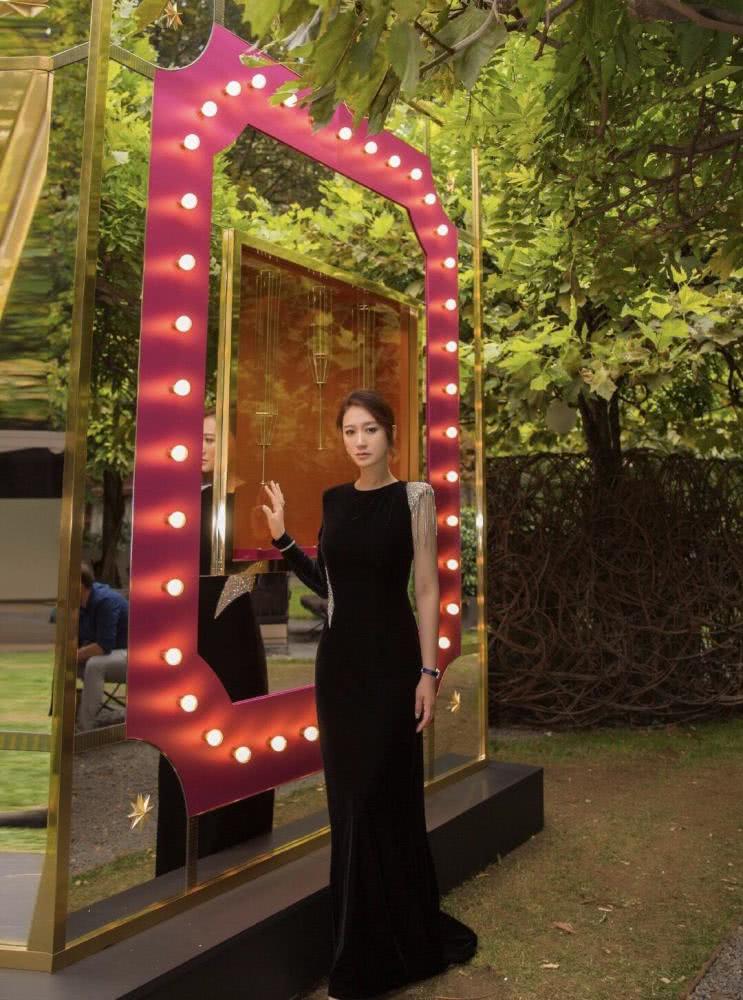 李小冉扎丸子头略显低调，身穿拼接色连衣裙优雅高贵