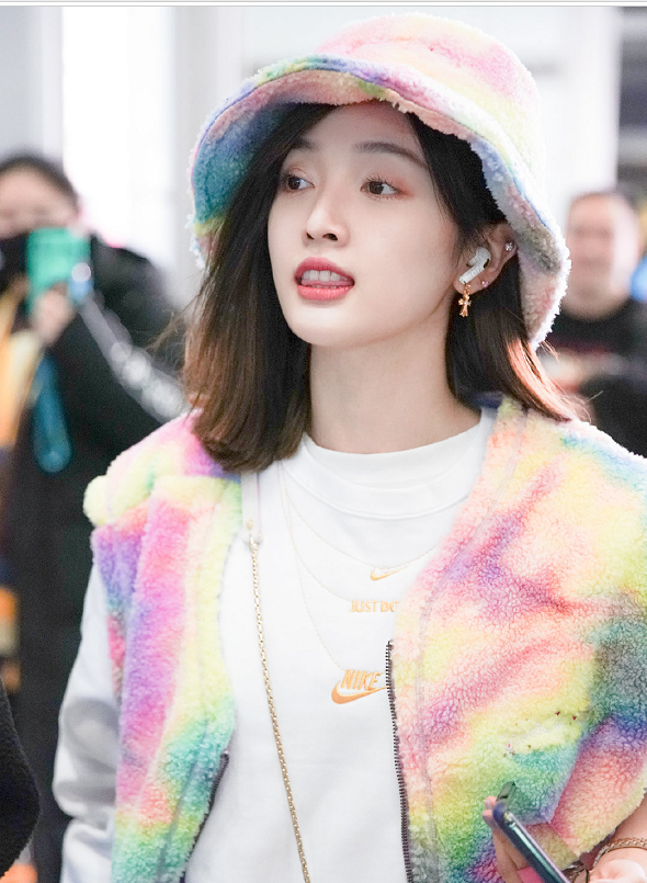 美女吴宣仪机场街拍:穿彩色马甲戴彩色渔夫帽一身彩虹穿搭,甜美又可爱