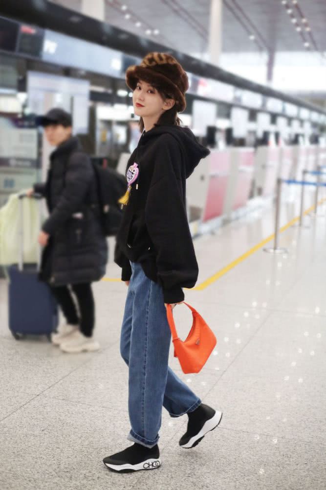 高挑美女乔欣戴焦糖色毛绒帽子，穿卫衣牛仔裤个性帅气