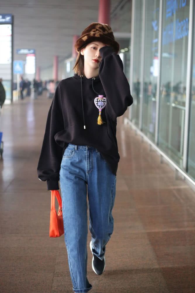 高挑美女乔欣戴焦糖色毛绒帽子，穿卫衣牛仔裤个性帅气