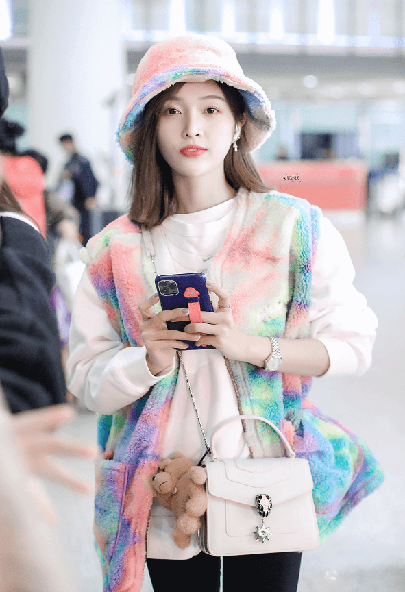 美女吴宣仪机场街拍:穿彩色马甲戴彩色渔夫帽一身彩虹穿搭,甜美又可爱