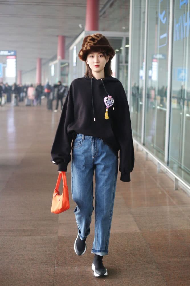 高挑美女乔欣戴焦糖色毛绒帽子,穿卫衣牛仔裤个性帅气