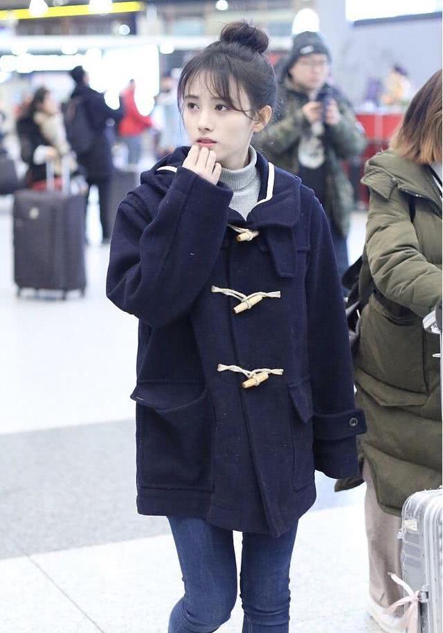 美女鞠婧祎穿牛角大衣配牛仔裤走机场,扎高丸子头太可爱
