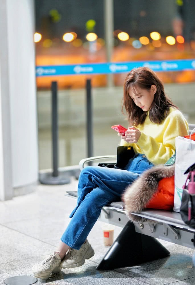 美女李一桐机场街拍：穿黄色毛衣配牛仔裤，双腿绕成麻花了