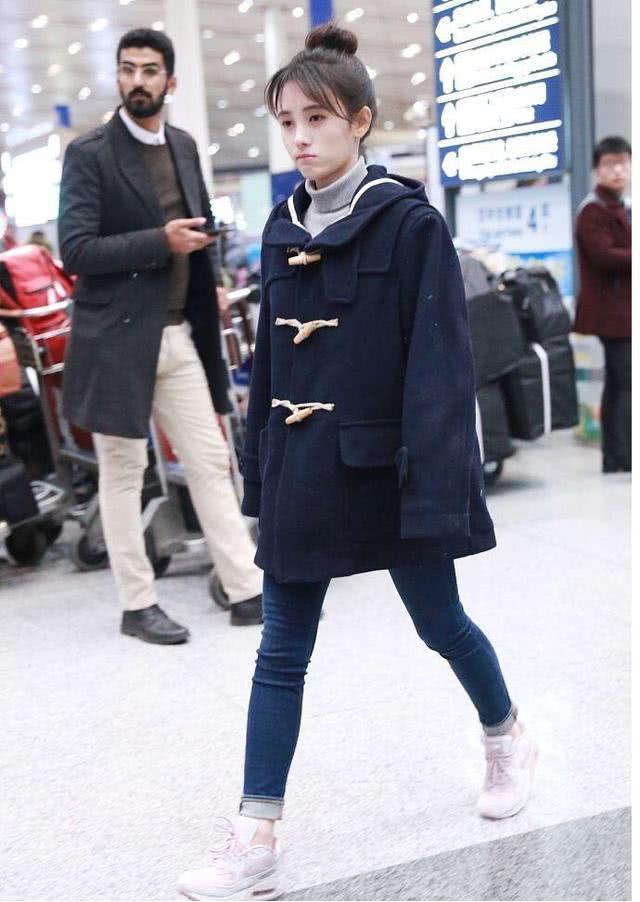 美女鞠婧祎穿牛角大衣配牛仔裤走机场,扎高丸子头太可爱
