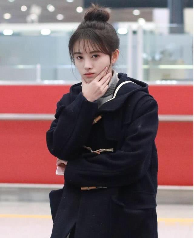 美女鞠婧祎穿牛角大衣配牛仔裤走机场,扎高丸子头太可爱