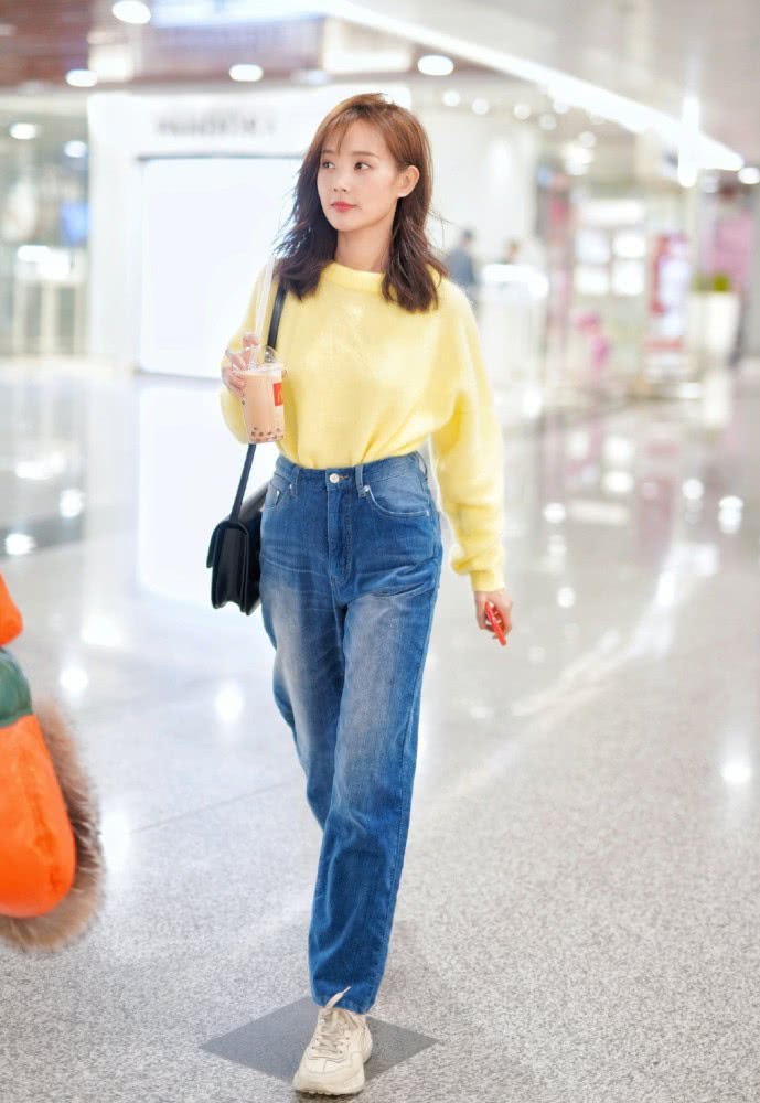 美女李一桐机场街拍：穿黄色毛衣配牛仔裤，双腿绕成麻花了