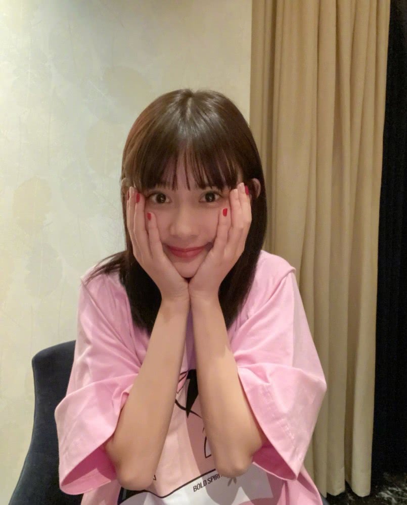 孟子义穿粉色T恤出镜，双手捧脸俏皮又甜美