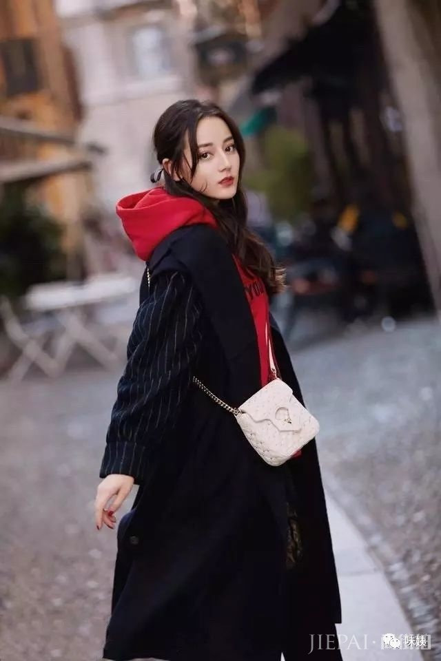 热巴黑色大衣搭配红色连帽卫衣,带着点缀的效果,鲜艳的红色凸显脸部的