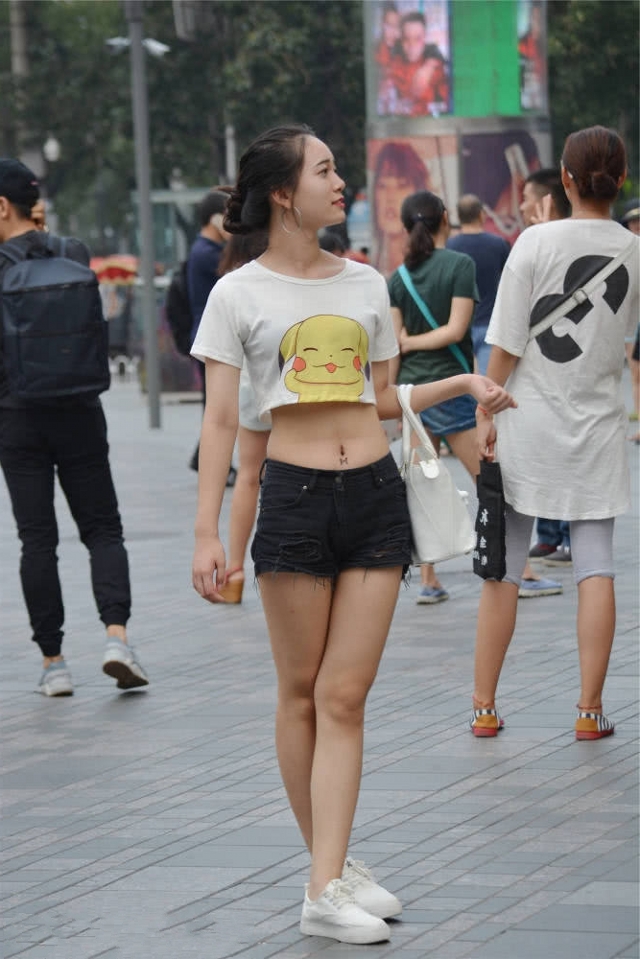 国内路人街拍，美女穿黑色低腰牛仔裤，多了几分俏丽感