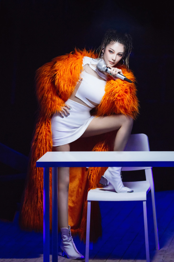 张雨绮穿透视拼接裙配橙色皮草,脚蹬椅子上性感又霸气