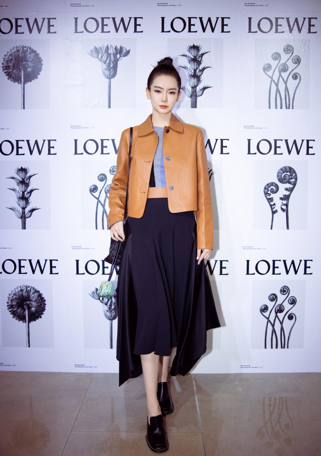 戚薇混搭粉红玩偶包身穿牛仔皮草配链条墨镜，彰显可爱俏皮