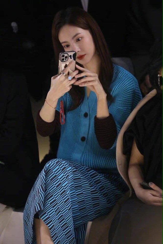 金晨看走秀台下手机拍摄不停,蓝色着装显得干练又有气质
