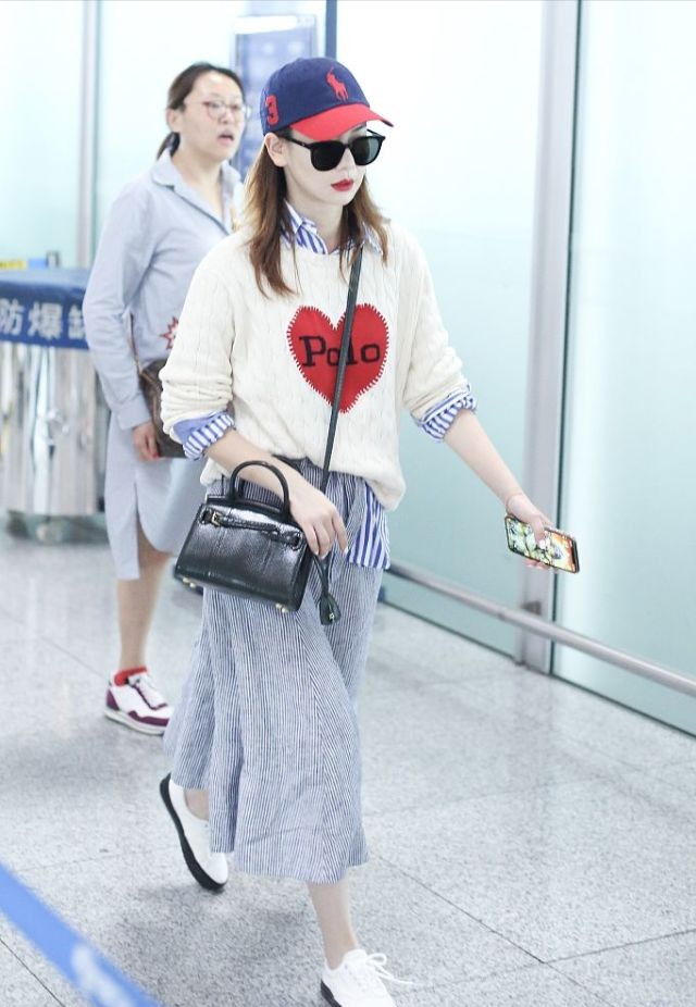 戚薇机场街拍:短发加上彩虹针织衫玩下身失踪,大长腿太性感