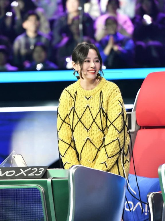 张靓颖参加综艺节目《梦想的声音》,微卷刘海搭配黄色毛衣嫩回少女