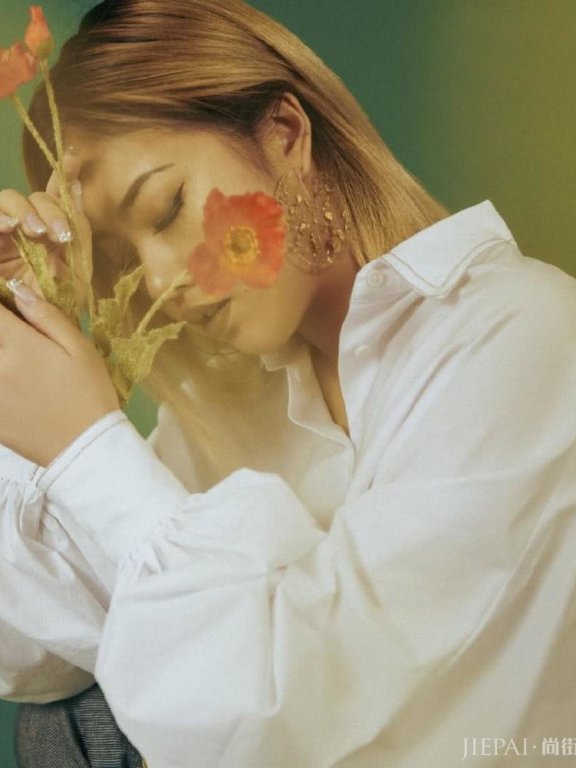 王菊穿白衬衫拿花朵,秀侧颜变美走清新范儿