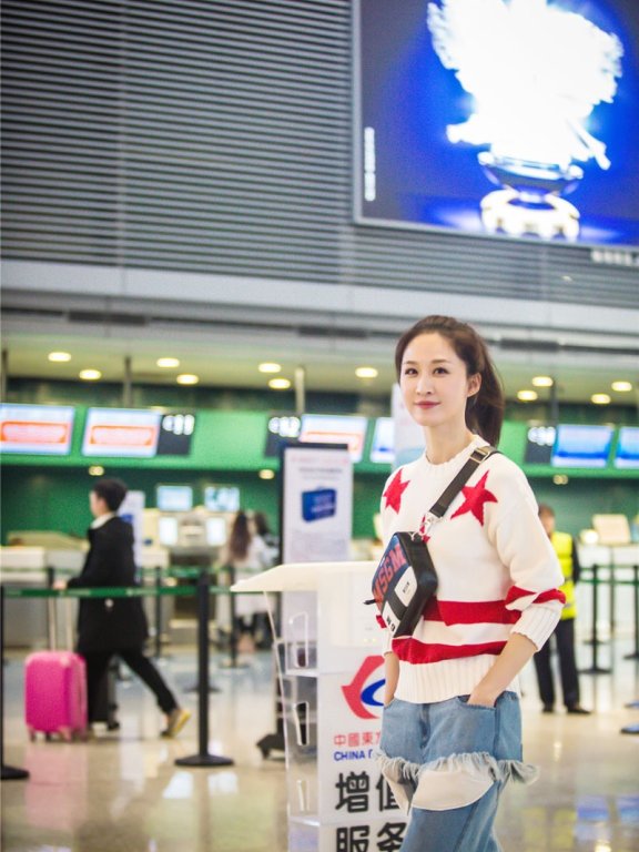 张雯机场街拍 造型简约破洞牛仔裤抢镜