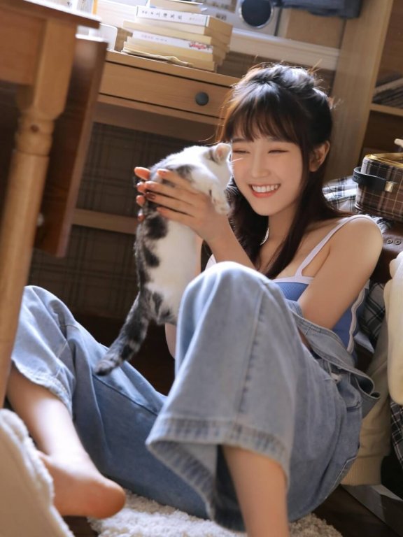 穿吊带装的活泼美女抱猫咪露出灿烂笑容私房图片