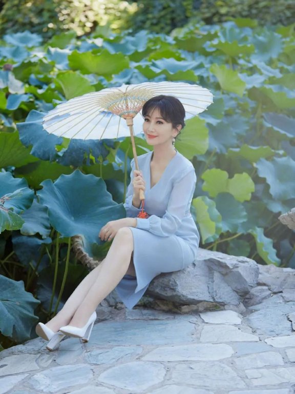 赵雅芝撑纸伞坐在荷塘前,人比花娇!
